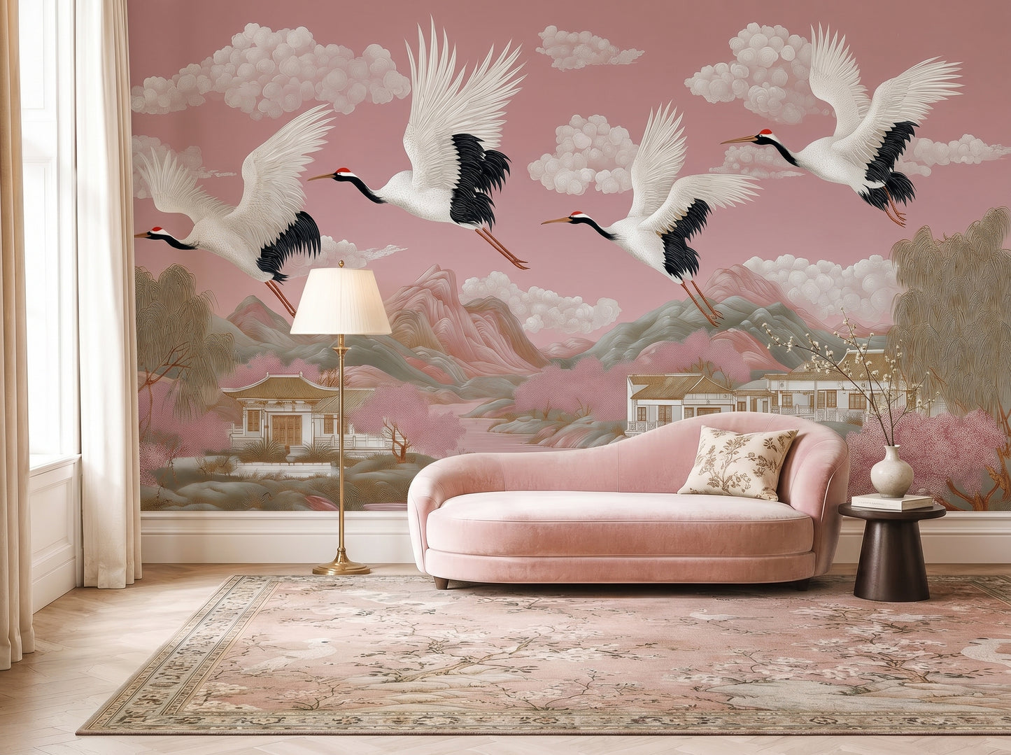 Blush pink chinoiserie crane wall mural in elegant living room with pink velvet sofa, featuring flying Japanese cranes, pagodas, mountains, cherry blossom trees, and panoramic Asian landscape wallpaper.