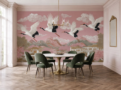 Elegant blush pink chinoiserie crane wall mural in luxury dining room featuring flying Japanese cranes, soft mountain landscape, pagodas, and cherry blossom scenery with sophisticated Asian-inspired wallpaper styling.